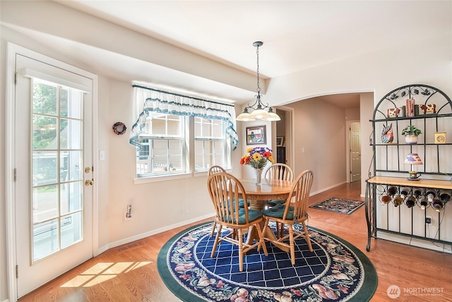 418 158th Pl NW, Arlington, WA 98223 - dining room featuring arched walkways, baseboards, and wood finished floors