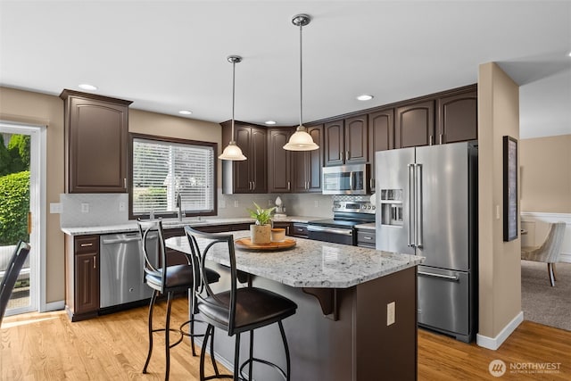 16520 136th Ave E, Puyallup, WA 98374 - kitchen featuring appliances with stainless steel finishes, dark brown cabinetry, light wood-style floors, healthy amount of natural light, and recessed lighting