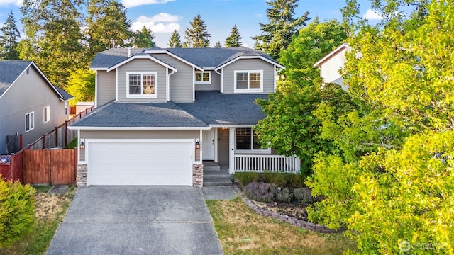 15235 105th Ave SE, Yelm, WA 98597 - view of front of home with a porch, concrete driveway, roof with shingles, and a garage
