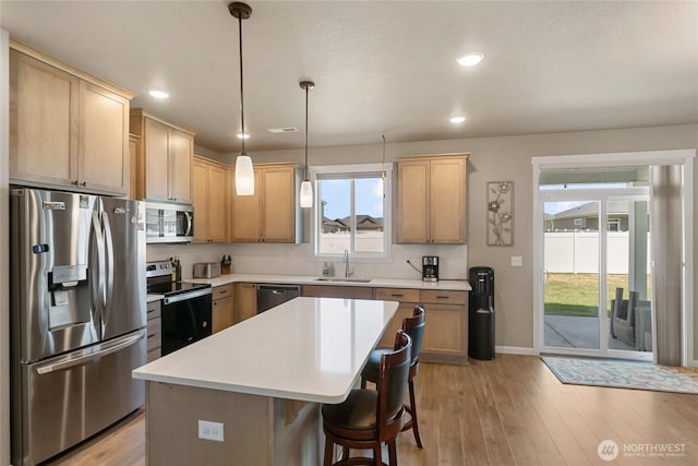 707 I St NE, Quincy, WA 98848 - kitchen featuring stainless steel appliances, a sink, light wood-style flooring, light countertops, and a kitchen island