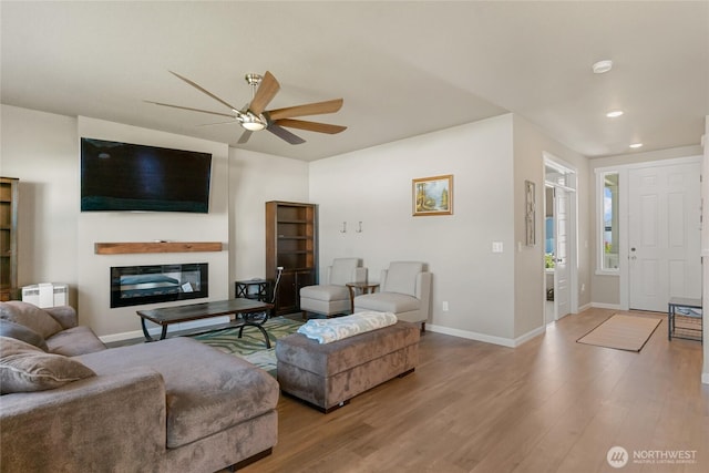 707 I St NE, Quincy, WA 98848 - living area with radiator heating unit, ceiling fan, a glass covered fireplace, baseboards, and recessed lighting