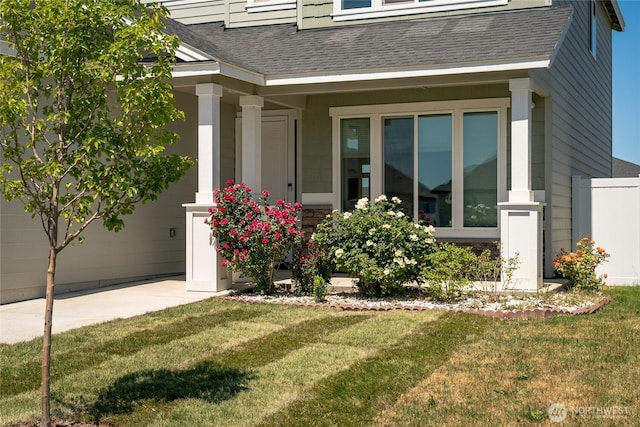 707 I St NE, Quincy, WA 98848 - view of exterior entry with a shingled roof, a yard, and concrete driveway