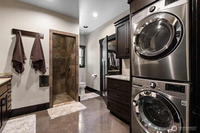 335 Brown Rd, Chehalis, WA 98532 - laundry room with stacked washing machine and dryer, baseboards, recessed lighting, heating unit, and dark tile patterned flooring