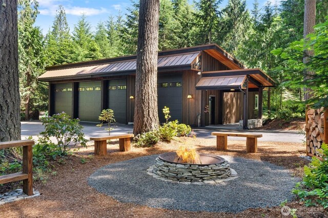 335 Brown Rd, Chehalis, WA 98532 - view of front facade with a standing seam roof, a garage, an outdoor fire pit, metal roof, and an outdoor structure