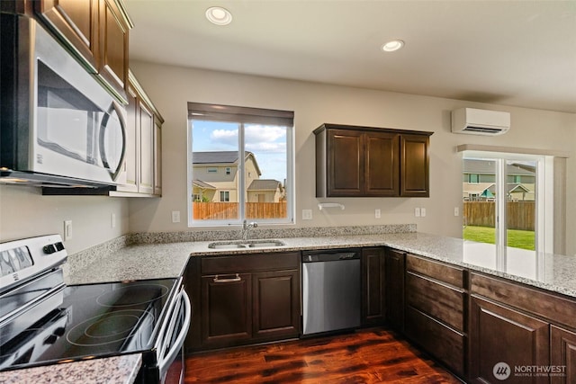 2212 N Creeksedge Way, Ellensburg, WA 98926 - kitchen featuring stainless steel appliances, a sink, an AC wall unit, dark wood-style floors, and dark brown cabinetry