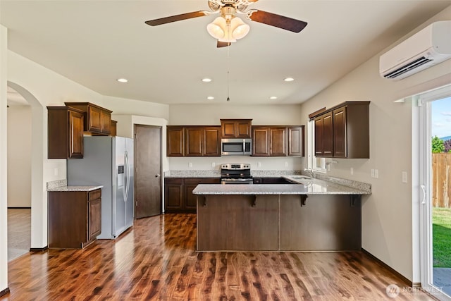 2212 N Creeksedge Way, Ellensburg, WA 98926 - kitchen featuring appliances with stainless steel finishes, a wall mounted air conditioner, a peninsula, dark wood finished floors, and a sink