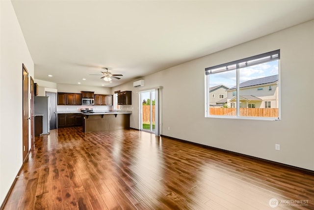 2212 N Creeksedge Way, Ellensburg, WA 98926 - unfurnished living room featuring a ceiling fan, a wall mounted air conditioner, dark wood finished floors, recessed lighting, and baseboards
