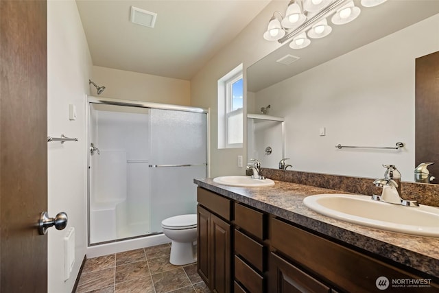 2212 N Creeksedge Way, Ellensburg, WA 98926 - bathroom with toilet, a shower stall, double vanity, and stone finish flooring