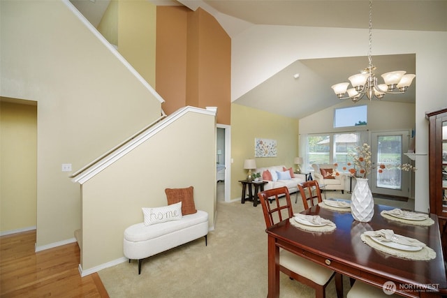 1110 63rd St E Unit 101, Auburn, WA 98092 - dining space featuring a chandelier, high vaulted ceiling, stairway, baseboards, and wood finished floors