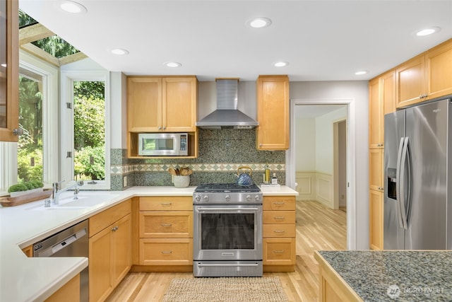 11750 NE 36th Pl, Bellevue, WA 98005 - kitchen with wall chimney range hood, stainless steel appliances, light wood-style floors, decorative backsplash, and wainscoting