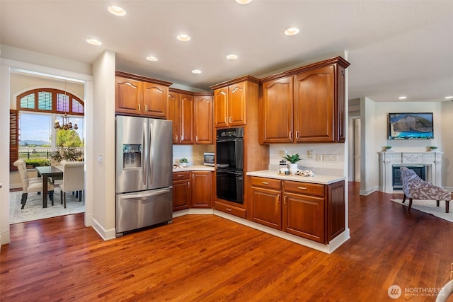 7212 Canterwood Dr SE, Olympia, WA 98513 - kitchen featuring stainless steel refrigerator with ice dispenser, light countertops, dark wood finished floors, brown cabinets, and recessed lighting