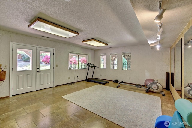 13311 SE 290th St, Auburn, WA 98092 - workout area featuring a textured ceiling, a textured wall, rail lighting, and baseboards