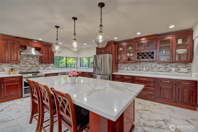 13311 SE 290th St, Auburn, WA 98092 - kitchen with appliances with stainless steel finishes, light marble finish floors, wall chimney exhaust hood, decorative backsplash, and recessed lighting