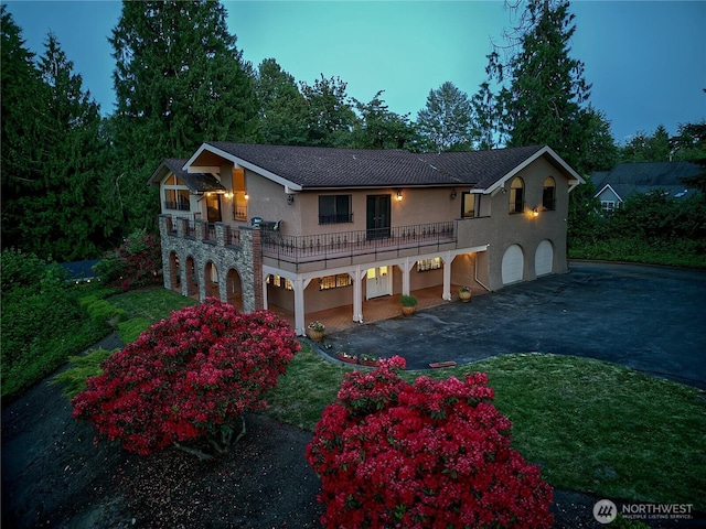 13311 SE 290th St, Auburn, WA 98092 - view of front of house featuring a garage, stucco siding, asphalt driveway, stone siding, and a balcony