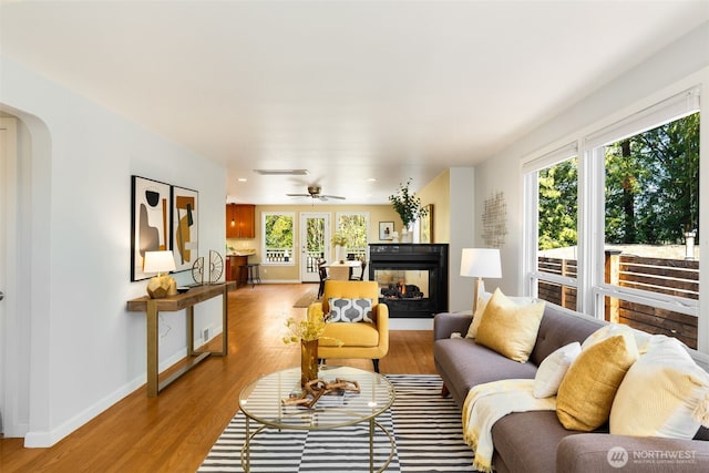2330 NE 103rd St, Seattle, WA 98125 - living area featuring light wood-style flooring, a multi sided fireplace, arched walkways, recessed lighting, and ceiling fan