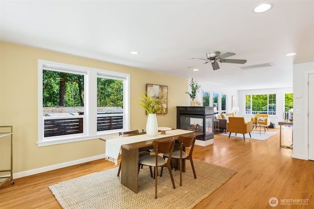 2330 NE 103rd St, Seattle, WA 98125 - dining area with a multi sided fireplace, light wood-style flooring, recessed lighting, and a ceiling fan