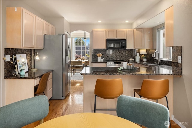 3316 Main Ave S, Renton, WA 98055 - kitchen with a sink, black microwave, stainless steel fridge, a peninsula, and arched walkways