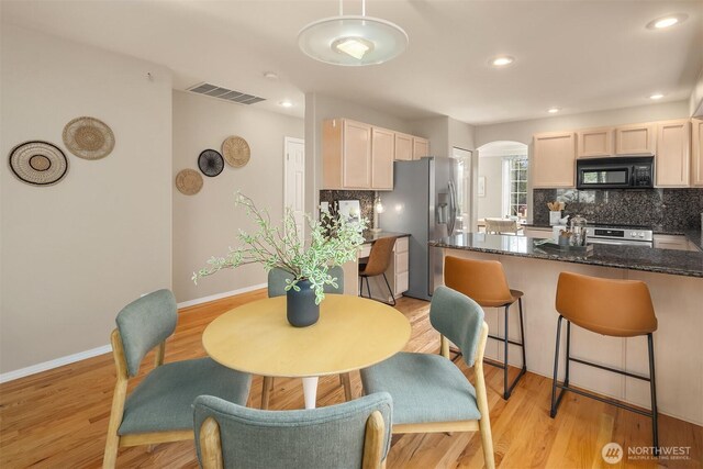 3316 Main Ave S, Renton, WA 98055 - dining area featuring arched walkways, light wood-type flooring, baseboards, and recessed lighting