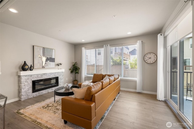 3123 148th St SW Unit A6, Lynnwood, WA 98087 - living room featuring a stone fireplace, light wood-style floors, recessed lighting, and baseboards