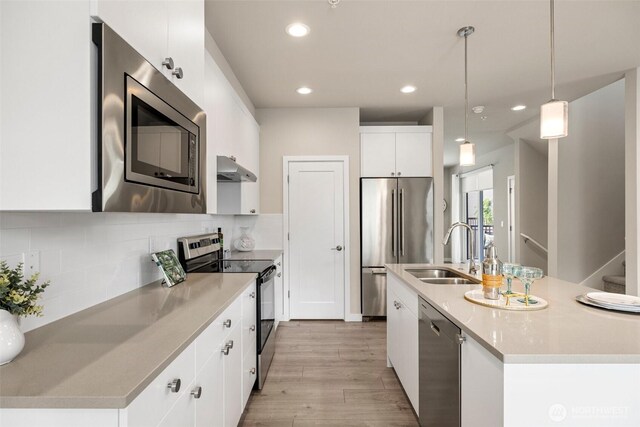 3123 148th St SW Unit A6, Lynnwood, WA 98087 - kitchen with appliances with stainless steel finishes, a sink, a center island with sink, light wood-style flooring, and white cabinetry