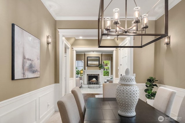 4503 229th Pl SE, Sammamish, WA 98075 - dining room with a chandelier, a wainscoted wall, a fireplace, a decorative wall, and ornamental molding