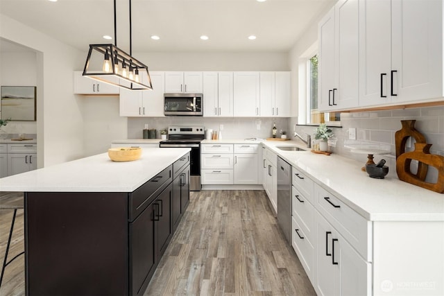 9245 Kelsey Ln SW, Seattle, WA 98106 - kitchen featuring stainless steel appliances, white cabinets, light wood-style flooring, light countertops, and recessed lighting