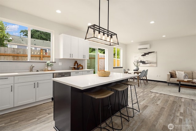 9245 Kelsey Ln SW, Seattle, WA 98106 - kitchen featuring backsplash, light wood-style floors, a wall unit AC, light countertops, and recessed lighting