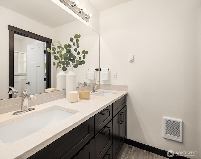 9245 Kelsey Ln SW, Seattle, WA 98106 - bathroom with heating unit, double vanity, wood finished floors, and tasteful backsplash