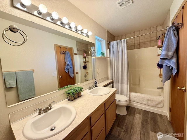 4304 Seville Dr SE, Lacey, WA 98503 - full bath with wood finished floors, a textured ceiling, double vanity, shower / bathtub combination with curtain, and toilet