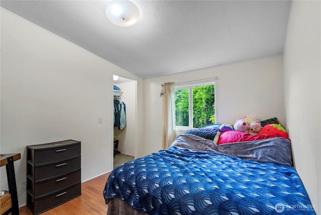 2614 48th Ave, Longview, WA 98632 - bedroom with wood finished floors, vaulted ceiling, and a walk in closet