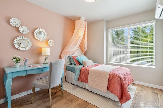 1322 194th St SE Unit H7, Bothell, WA 98012 - bedroom featuring wood finished floors, baseboards, and a wall mounted air conditioner