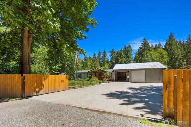 16605 259th Avenue Ct E, Buckley, WA 98321 - garage with driveway, a gate, and view of wooded area