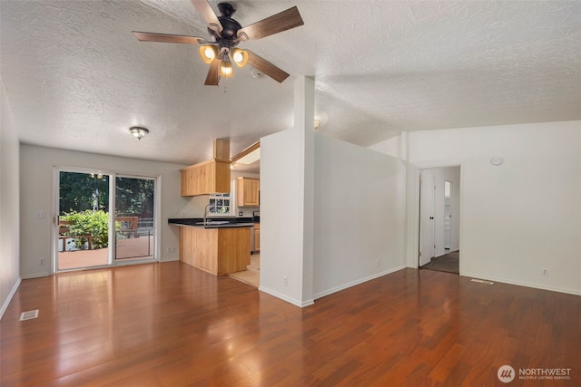 16605 259th Avenue Ct E, Buckley, WA 98321 - unfurnished living room featuring wood finished floors, a textured ceiling, a ceiling fan, baseboards, and lofted ceiling
