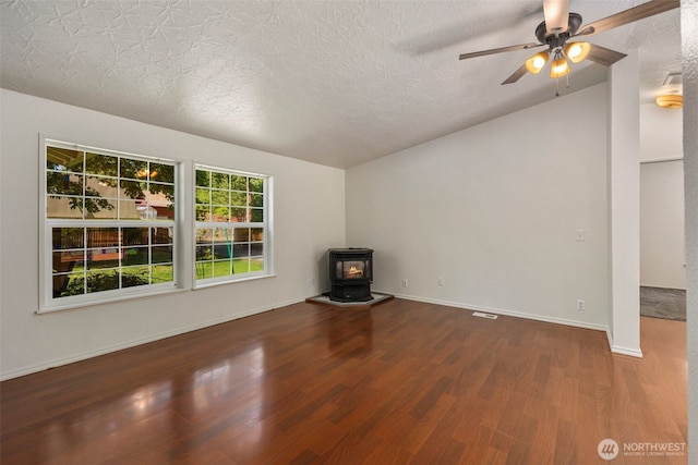 16605 259th Avenue Ct E, Buckley, WA 98321 - unfurnished living room with wood finished floors, a wood stove, a textured ceiling, ceiling fan, and baseboards