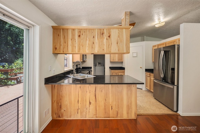 16605 259th Avenue Ct E, Buckley, WA 98321 - kitchen with freestanding refrigerator, a sink, a peninsula, and dark countertops