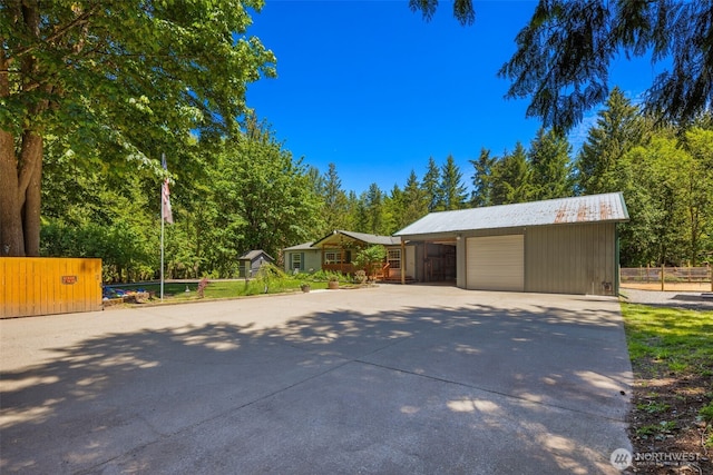 16605 259th Avenue Ct E, Buckley, WA 98321 - garage with a garage, view of scattered trees, and driveway