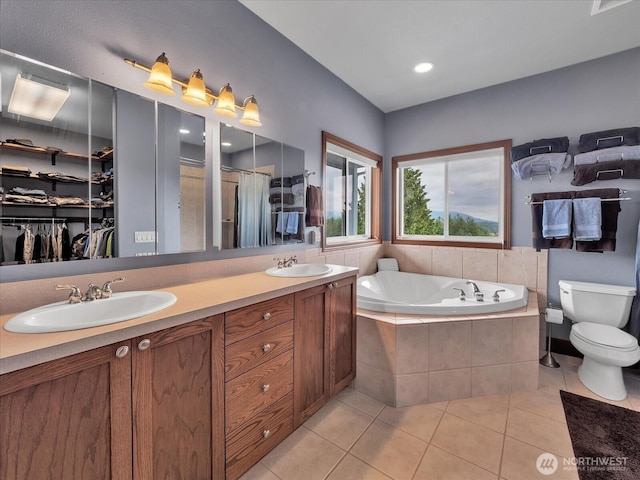 18754 Kim Pl, Burlington, WA 98233 - bathroom featuring tile patterned floors, a bath, double vanity, toilet, and a walk in closet