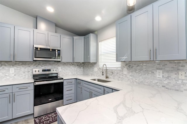 28209 241st Ave SE, Maple Valley, WA 98038 - kitchen featuring appliances with stainless steel finishes, a sink, gray cabinetry, vaulted ceiling, and light stone counters
