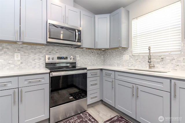 28209 241st Ave SE, Maple Valley, WA 98038 - kitchen with appliances with stainless steel finishes, a sink, gray cabinetry, light countertops, and tasteful backsplash