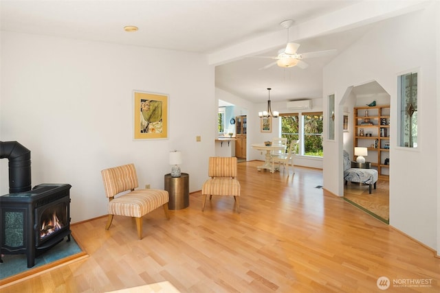 7459 SW 255th St, Vashon, WA 98070 - sitting room with a wood stove, a wall mounted air conditioner, light wood-type flooring, a ceiling fan, and a chandelier
