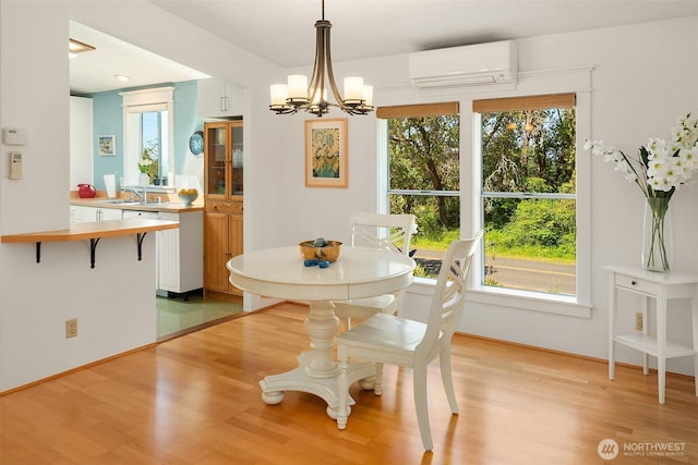 7459 SW 255th St, Vashon, WA 98070 - dining space with a wall mounted air conditioner, light wood-type flooring, and healthy amount of natural light