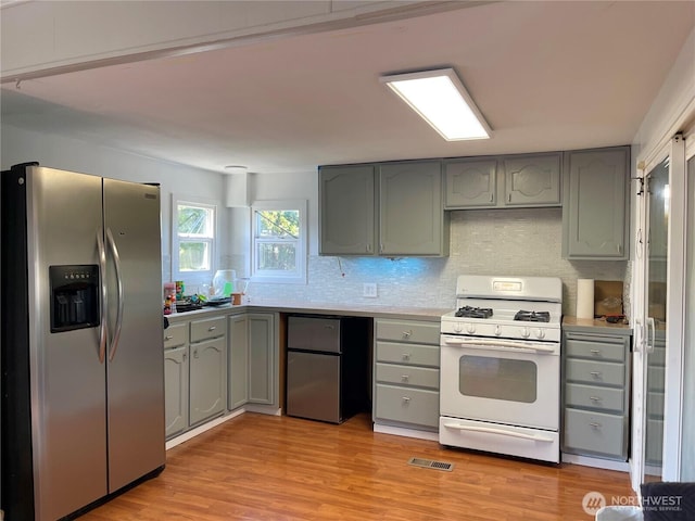 22000 29th Ct S Unit 16, Des Moines, WA 98198 - kitchen featuring stainless steel fridge with ice dispenser, gas range gas stove, gray cabinets, and stainless steel refrigerator