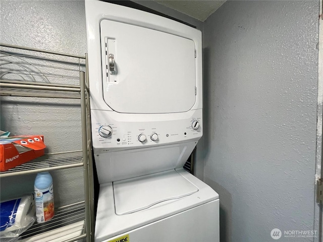 22000 29th Ct S Unit 16, Des Moines, WA 98198 - laundry area featuring stacked washer and clothes dryer and a textured wall