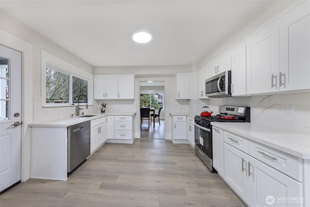 2333 31st Ave S, Seattle, WA 98144 - kitchen with appliances with stainless steel finishes, a sink, backsplash, and white cabinets
