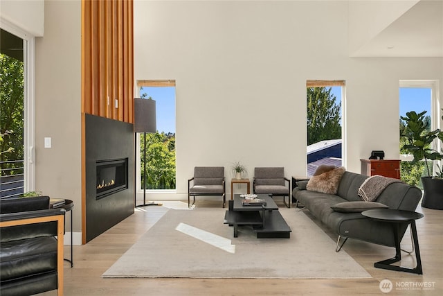 10227 26th Ave SW, Seattle, WA 98146 - living room with light wood-type flooring, a large fireplace, plenty of natural light, and a high ceiling