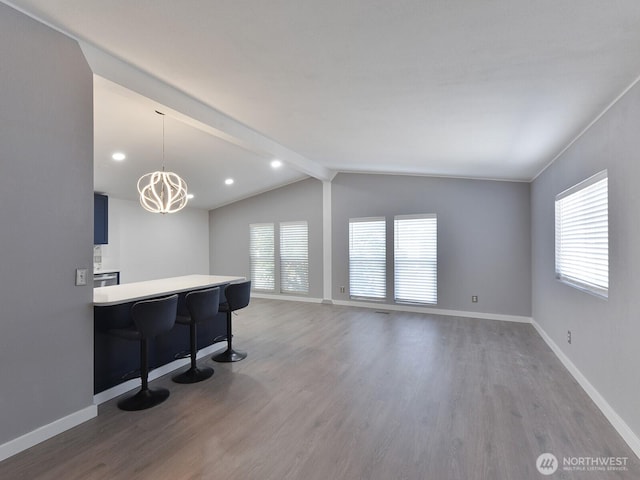 27460 149th Pl SE Unit 85, Kent, WA 98042 - kitchen featuring wood finished floors, baseboards, a kitchen breakfast bar, light countertops, and a peninsula