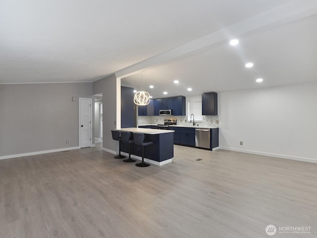 27460 149th Pl SE Unit 85, Kent, WA 98042 - kitchen featuring appliances with stainless steel finishes, a kitchen bar, light countertops, recessed lighting, and light wood-style flooring