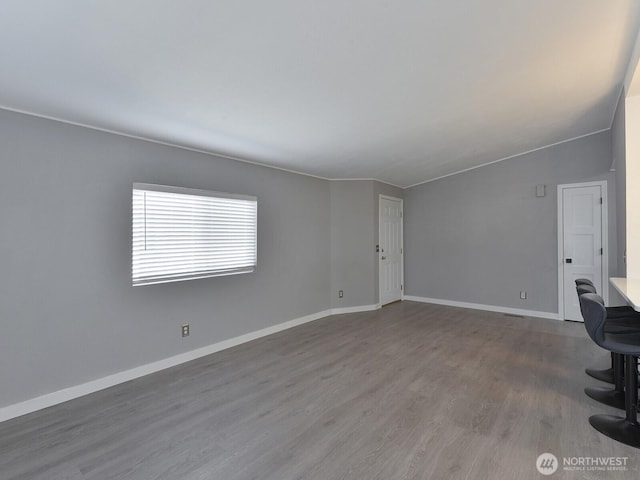 27460 149th Pl SE Unit 85, Kent, WA 98042 - unfurnished living room featuring wood finished floors, baseboards, and vaulted ceiling