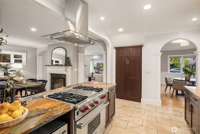 2532 Crestmont Pl W, Seattle, WA 98199 - kitchen featuring high end range, island range hood, ornamental molding, light stone countertops, and a glass covered fireplace