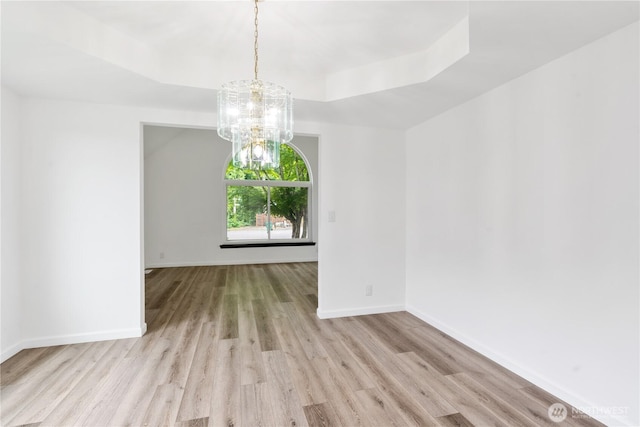 1258 NW Timber Shadow Ct, Silverdale, WA 98380 - empty room with wood finished floors, a tray ceiling, a chandelier, and baseboards